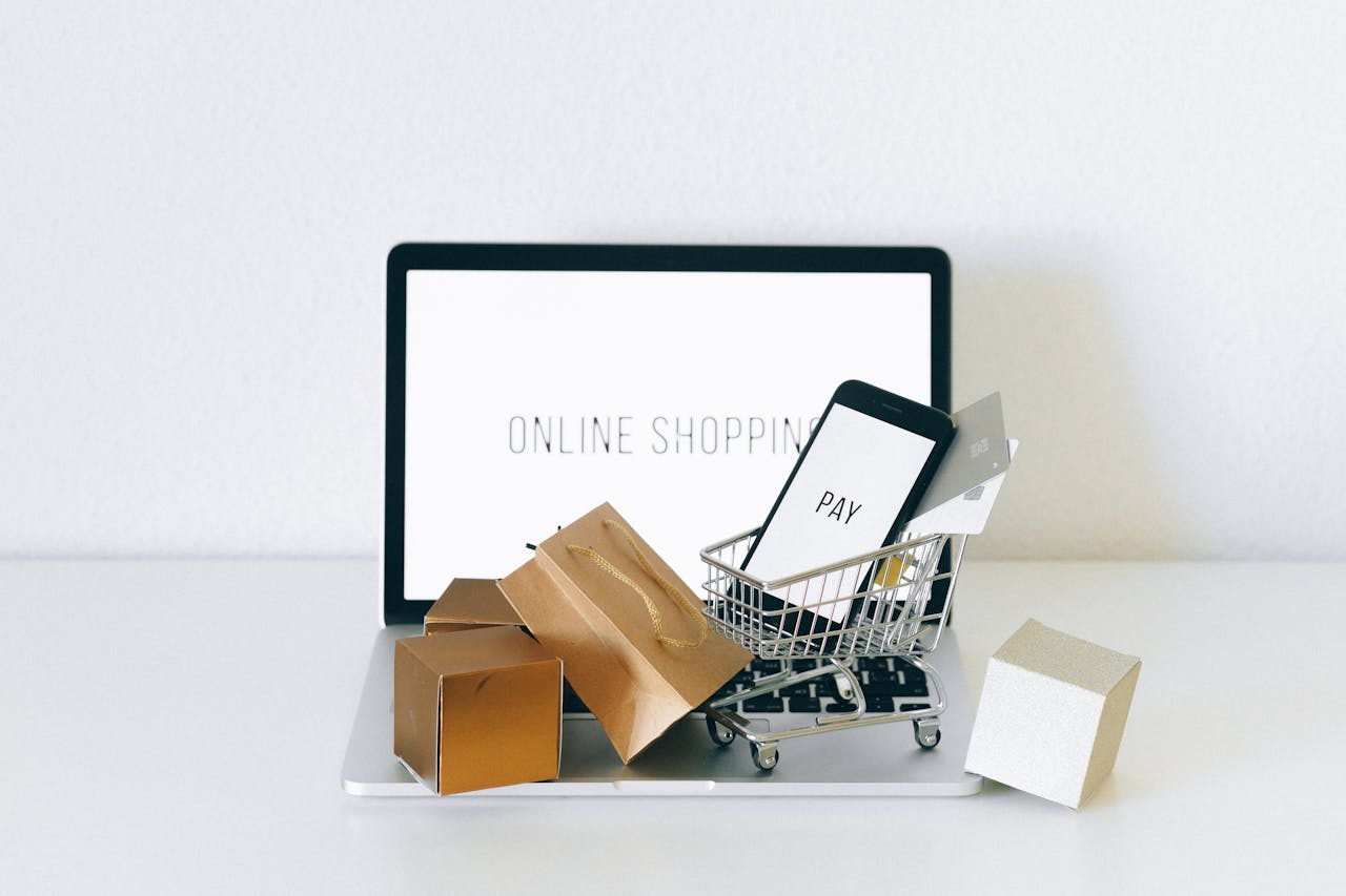 Display of online shopping theme with mini cart and payment devices on laptop.